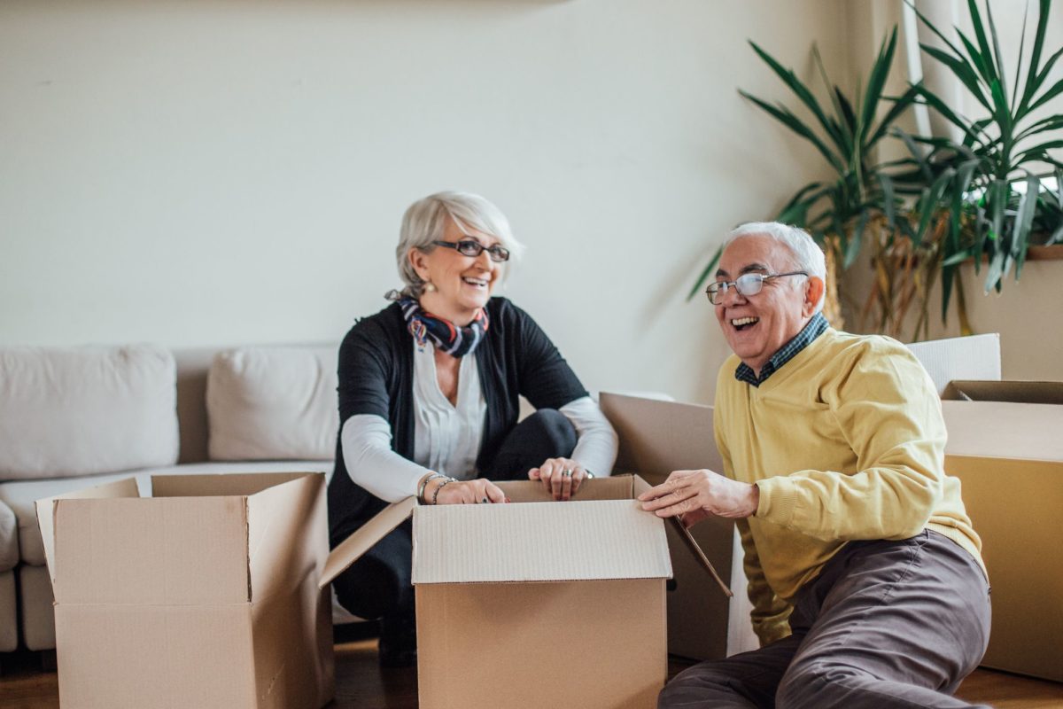 couple with moving box sitting on floor