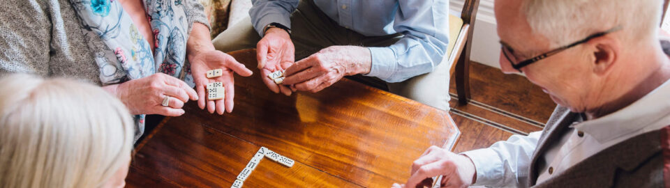 Arial view of a group of seniors playing dominos on a table